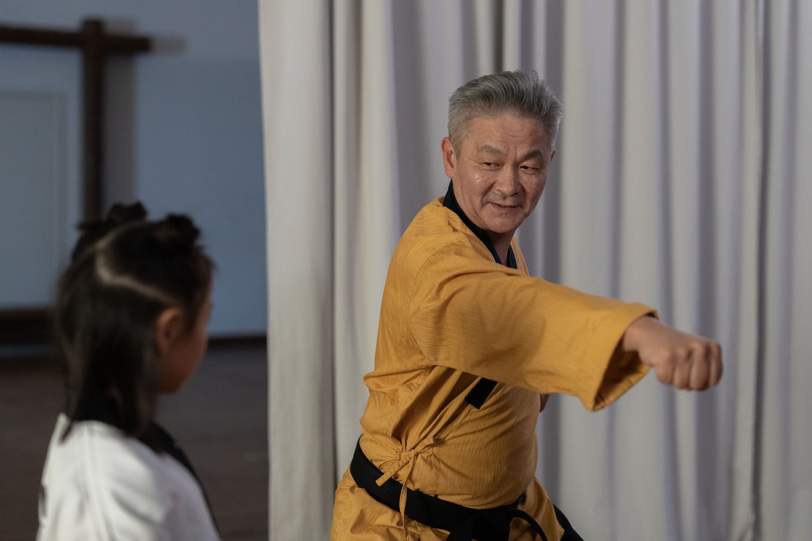 Sensei Vikram Nambiar in a yellow gi teaching a young student