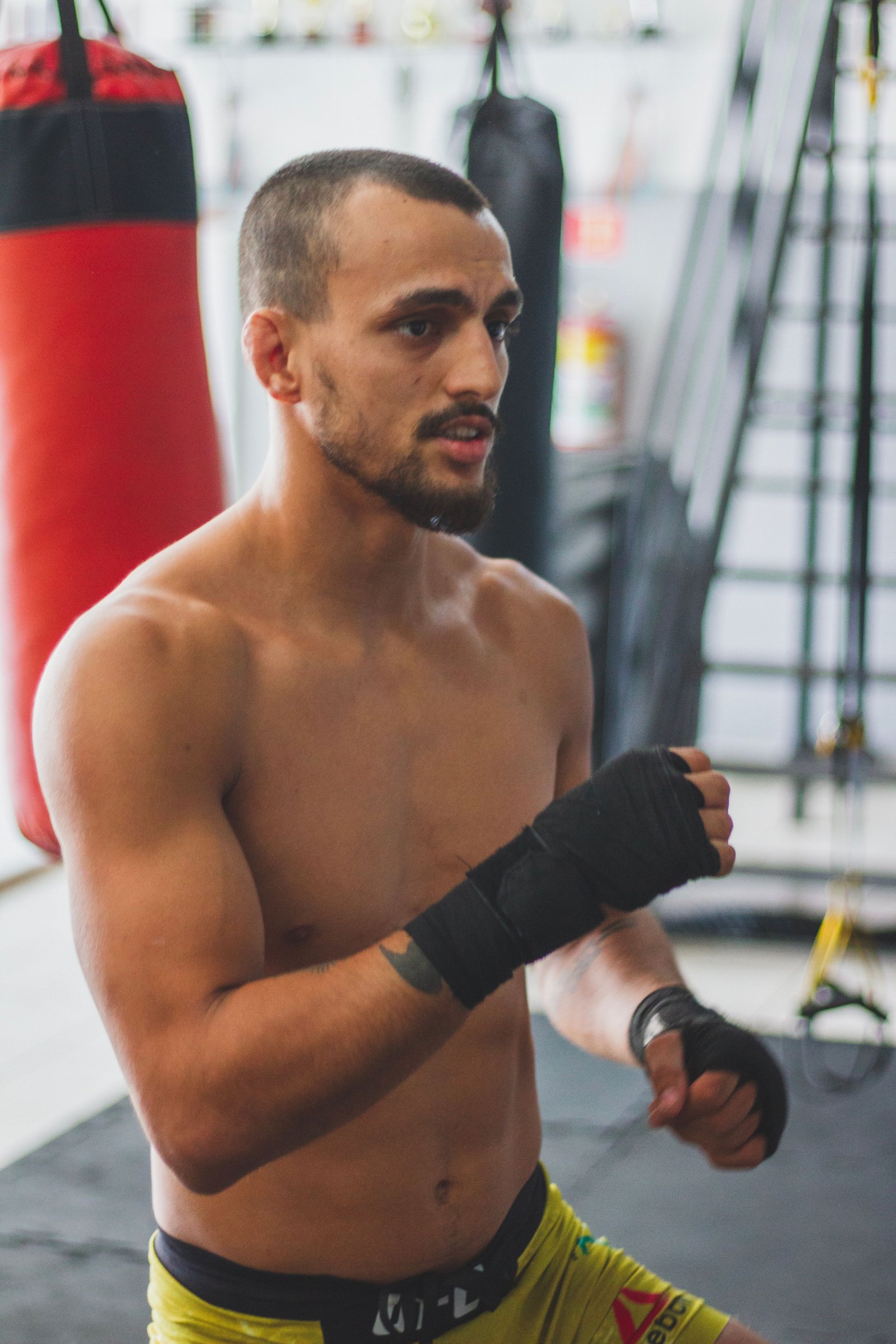 Coach Samuel D'Souza in hand wraps in a boxing gym